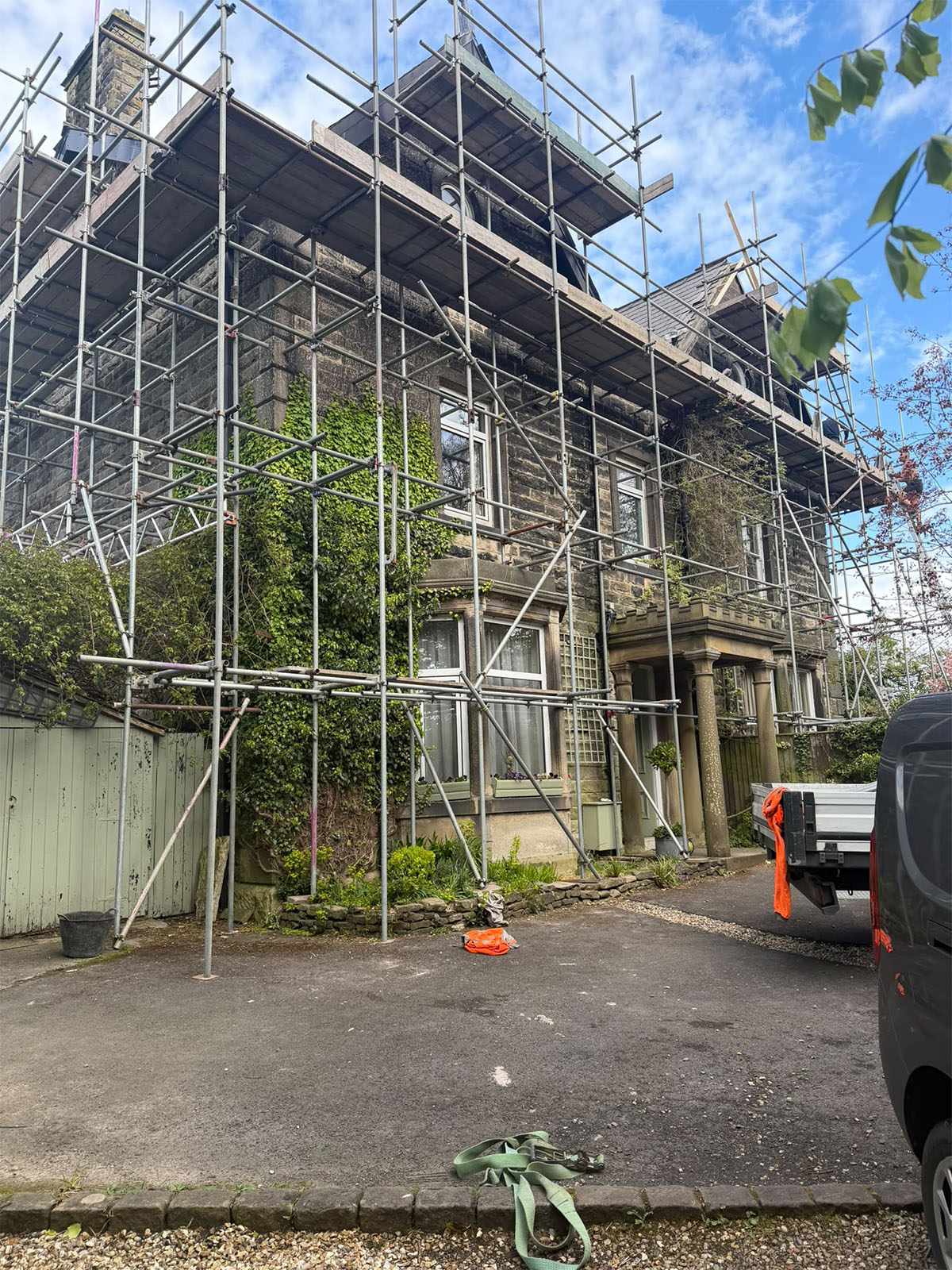 Scaffolding surrounding a stone property for roof and exterior access
